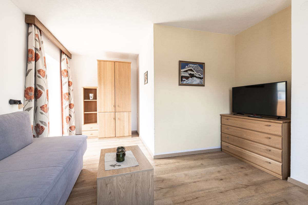 Helles Wohnzimmer mit Sofa und Smart TV