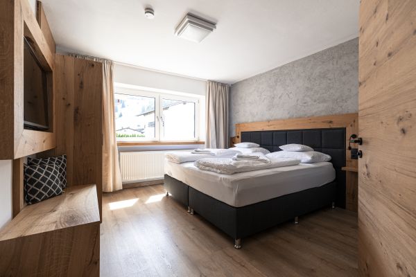 Schlafzimmer mit Doppelbett und Bergblick im Apartment Grubigstein Schlafzimmer mit Doppelbett und Bergblick im Apartment Grubigstein