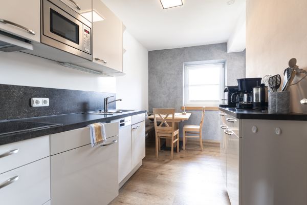 Moderne Wohnküche mit Essbereich und Kaffeemaschine Moderne Wohnküche mit Essbereich und Kaffeemaschine