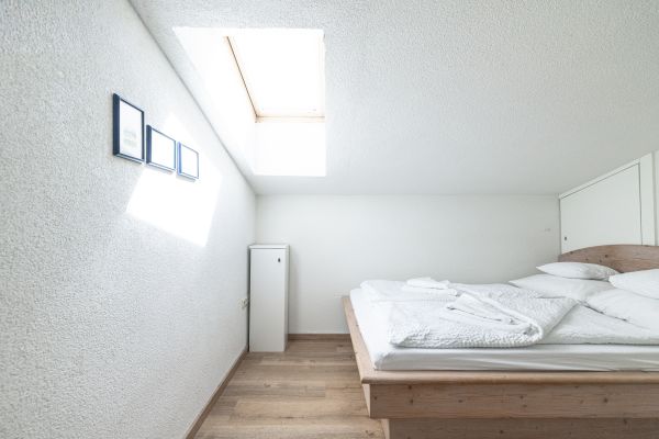 Schlafzimmer mit Dachfenster im Apartment Daniel